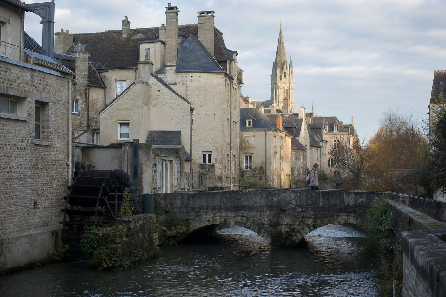 Maisons anciennes le long de l'Aure et flèche de la cathédrale de Bayeux au petit matin