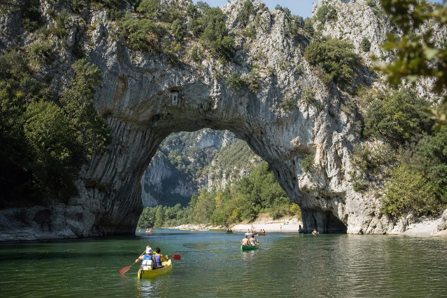 Arche naturelle au-dessus d'une rivière verte avec canoës qui passent dessous