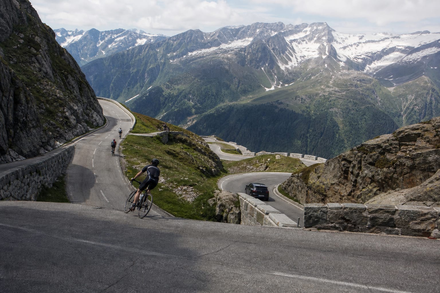 Route de col alpin en lacets avec vue sur des sommets enneigés