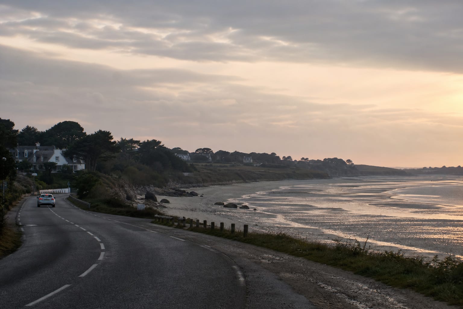 Route côtière bretonne longeant une baie de sable à marée basse