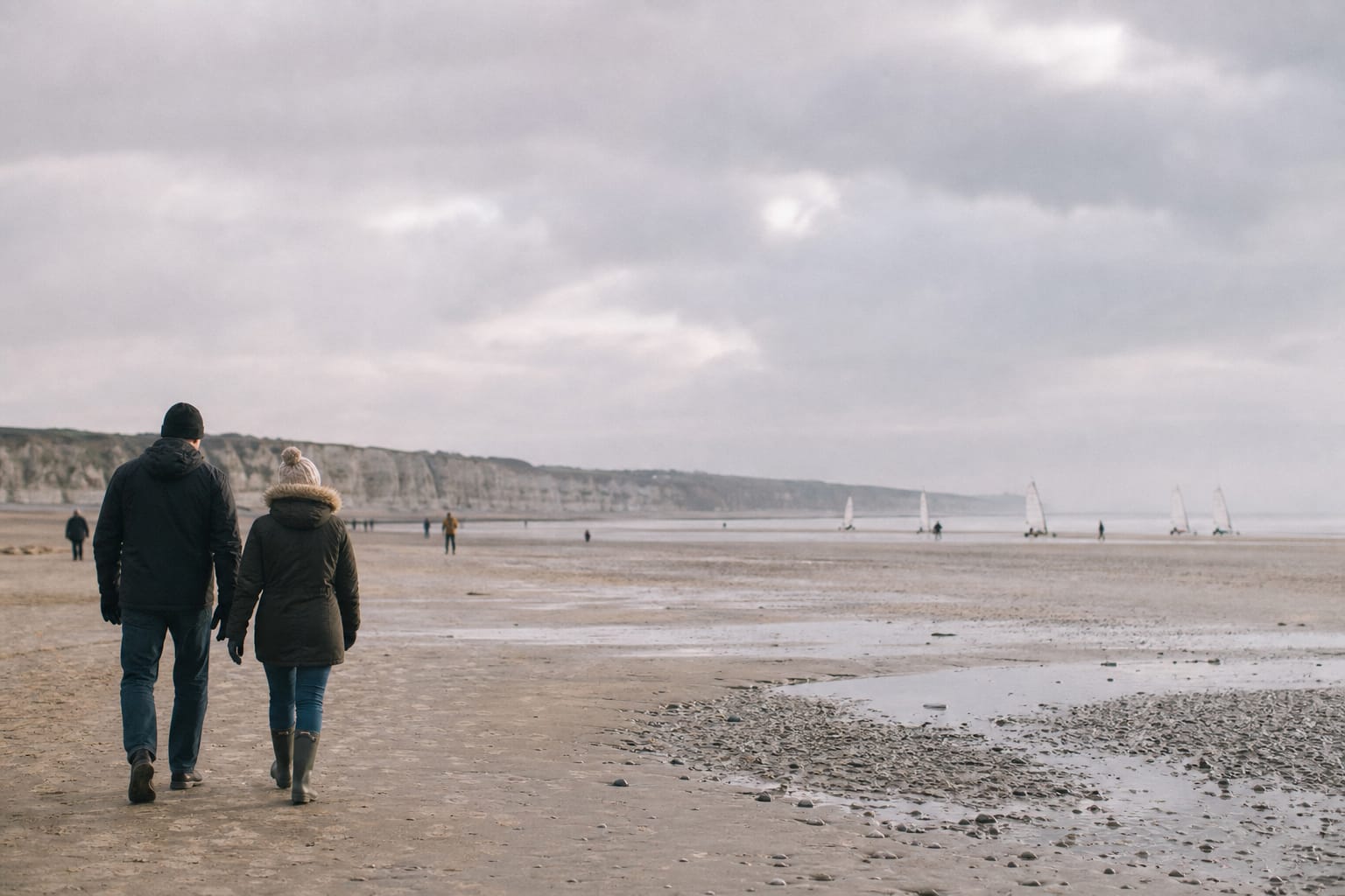 Vaste plage de sable à marée basse sur la Côte d'Opale sous un ciel de nuages bas