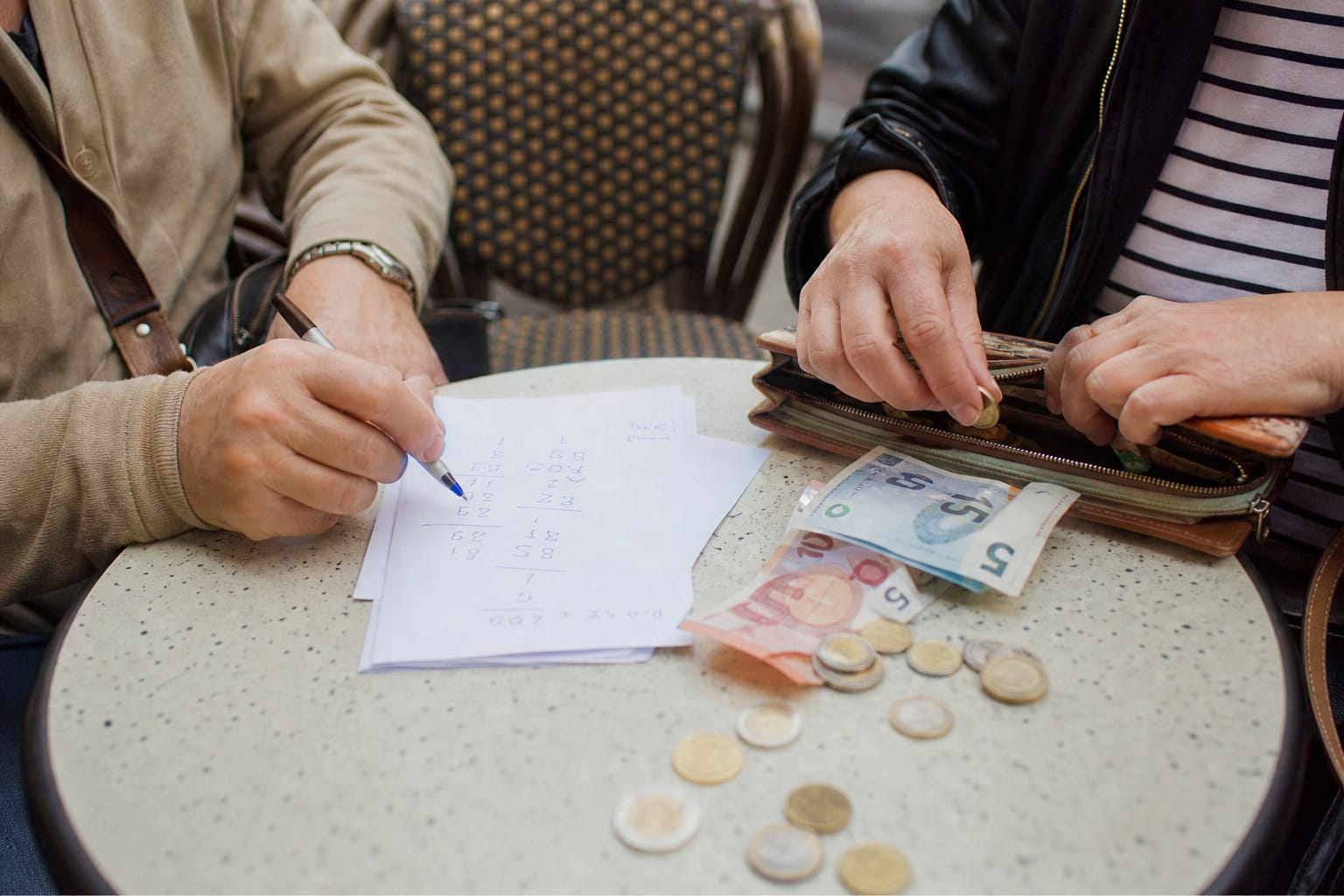Addition et monnaie posées sur une table de café