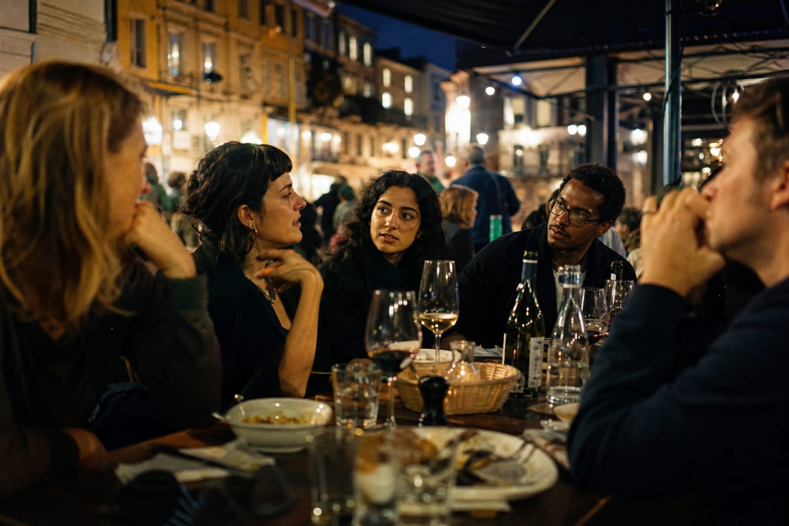 Groupe d'amis attablés en terrasse en soirée