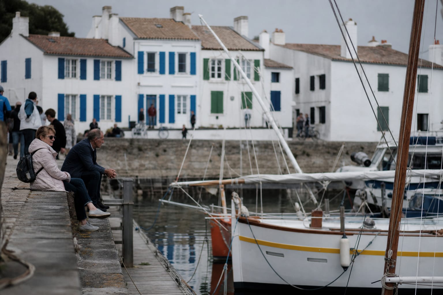 Petit port insulaire avec bateaux et maisons blanches à volets colorés