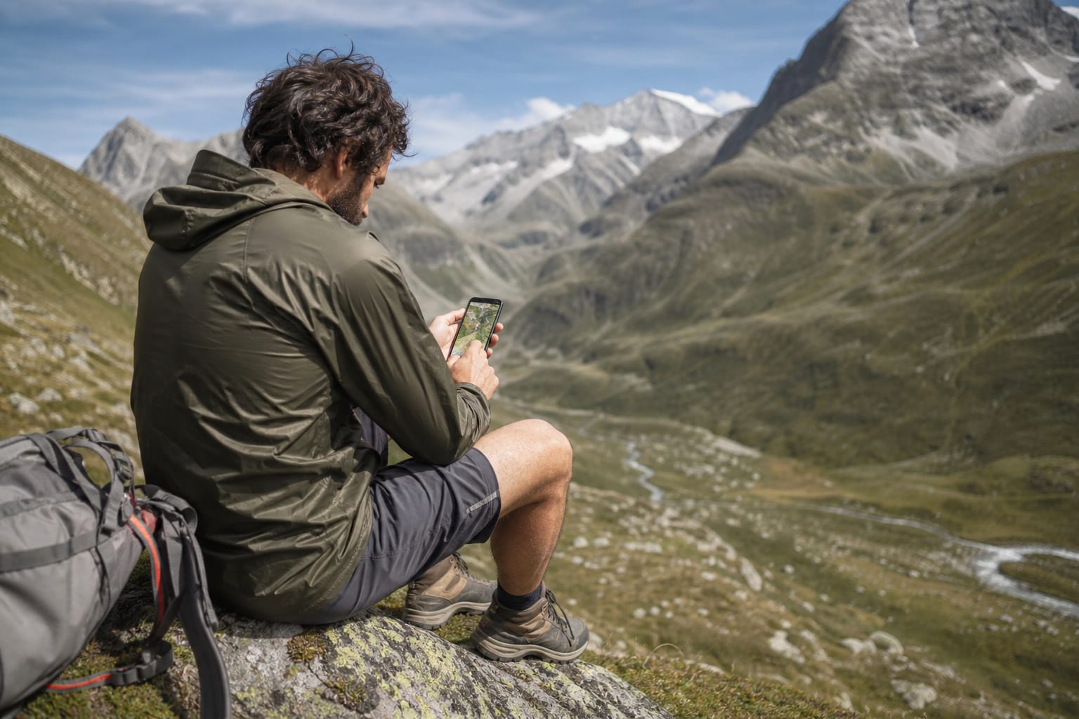 Randonneur consultant une carte hors ligne sur son téléphone dans une vallée encaissée