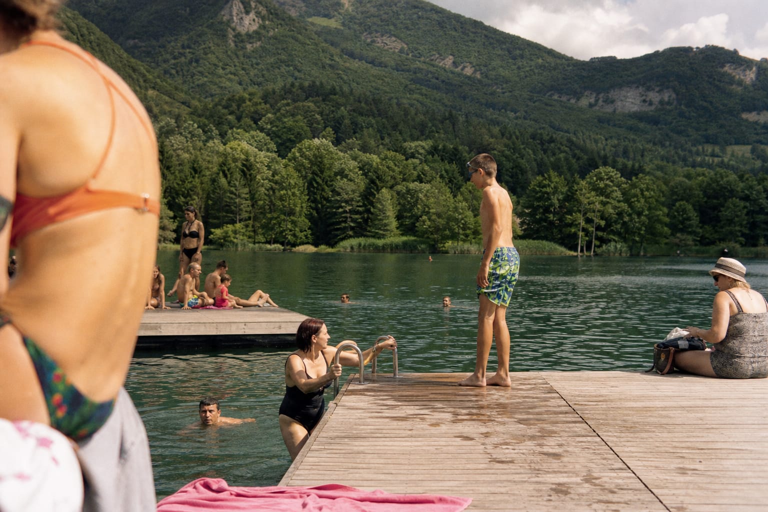 Lac de montagne avec pontons de bois et baigneurs en été