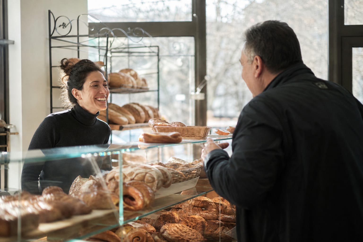 Échange entre un commerçant et un client au comptoir d'une boulangerie de quartier