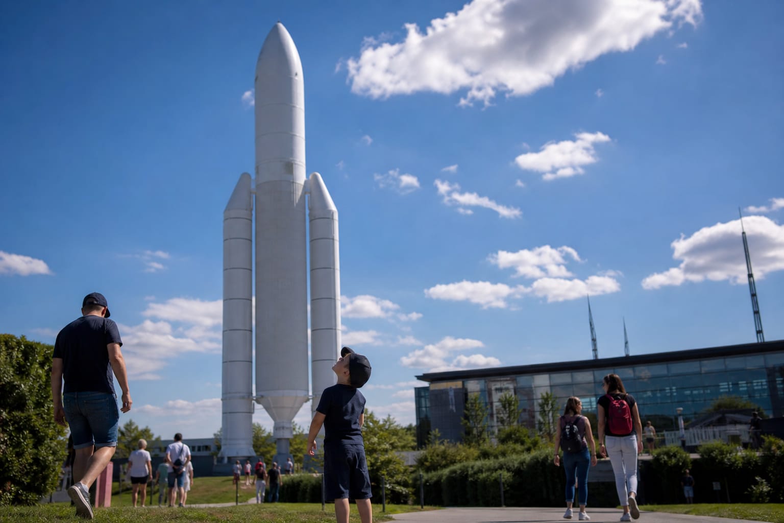 Réplique grandeur nature de la fusée Ariane 5 dans le parc de la Cité de l'espace à Toulouse, familles marchant sur les pelouses