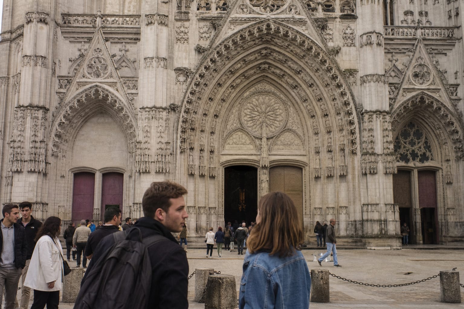 Façade de cathédrale gothique avec visiteurs en contrebas