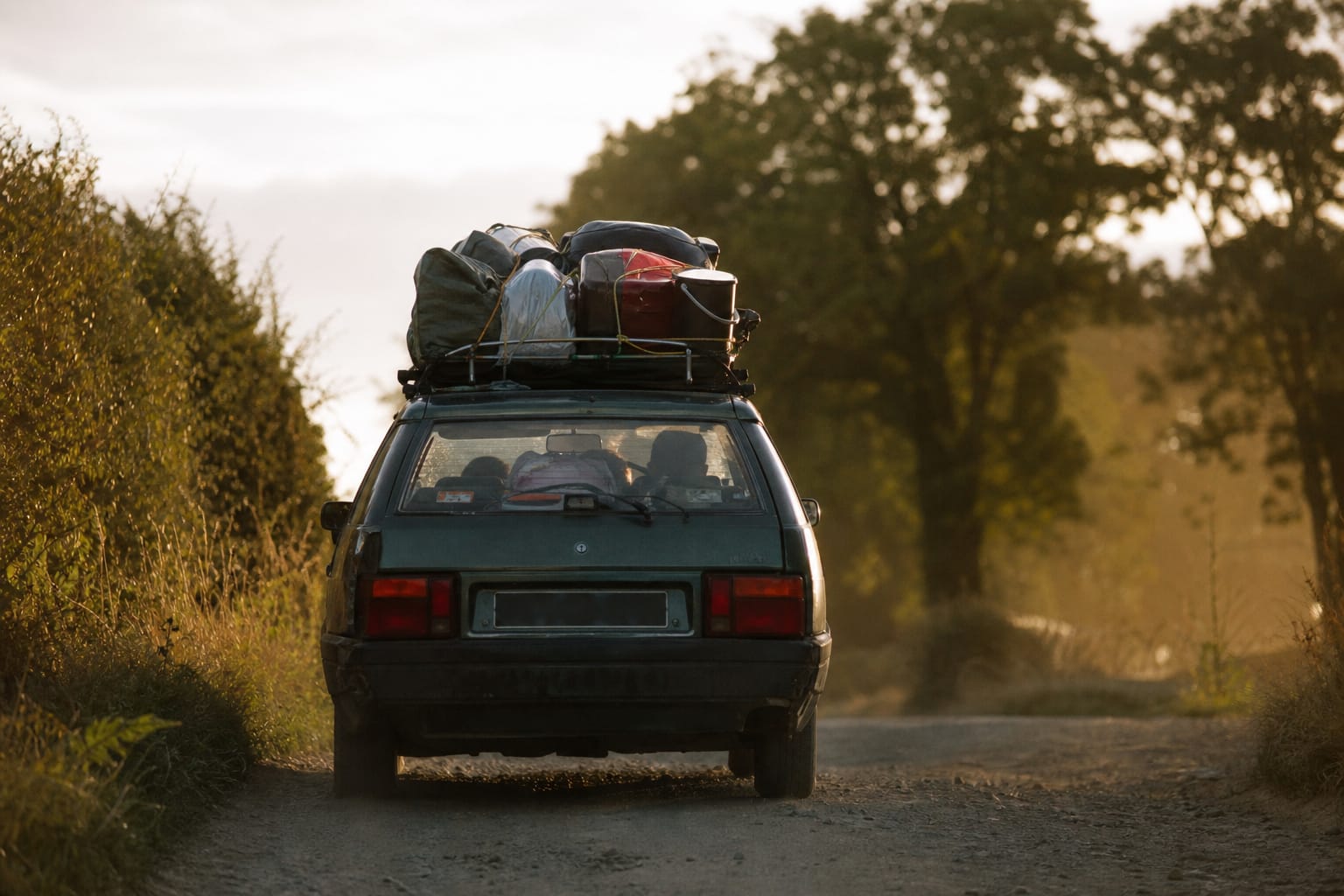 Route de campagne au petit matin avec une voiture chargée