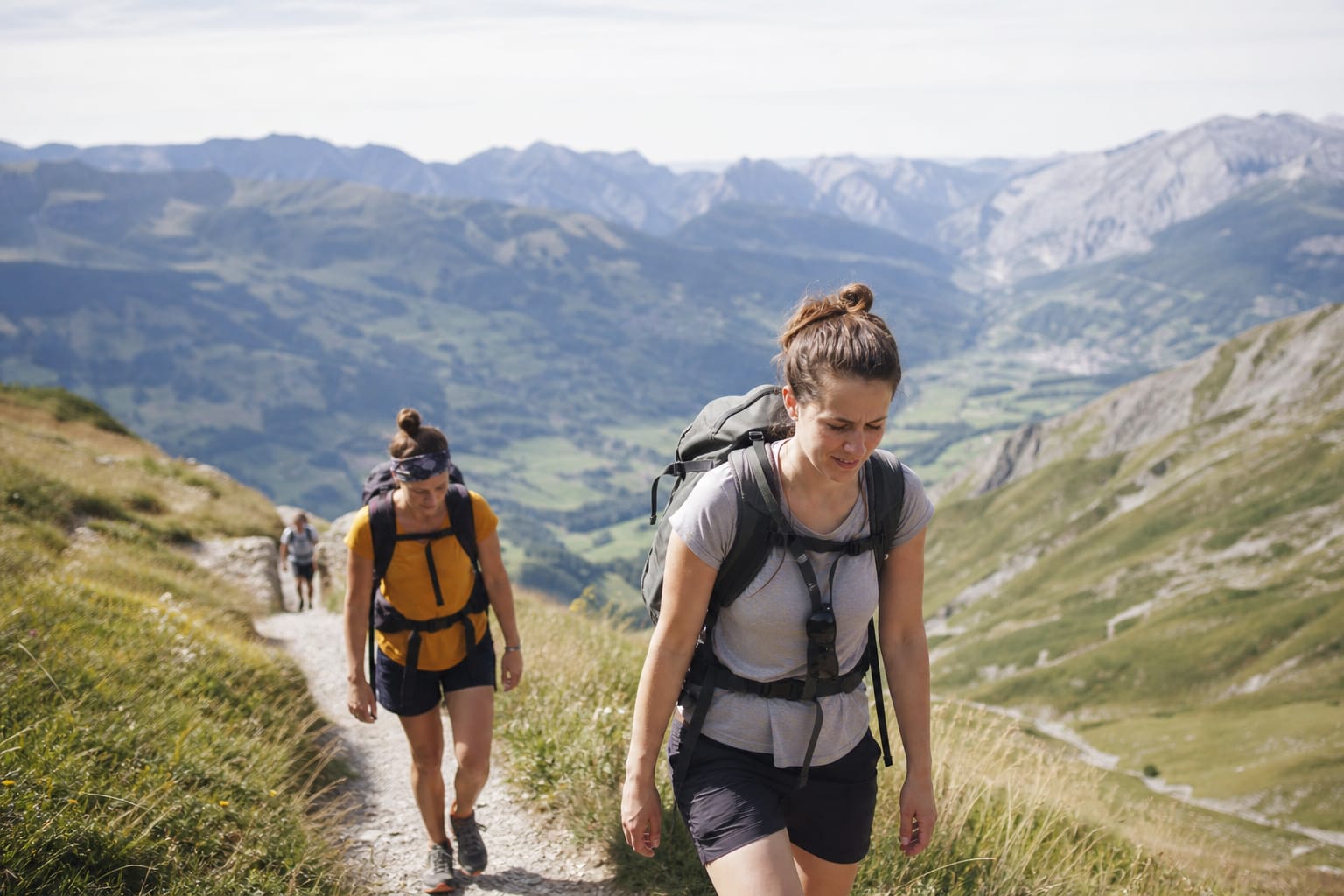 Randonneurs sur un sentier de montagne avec vue dégagée sur une vallée