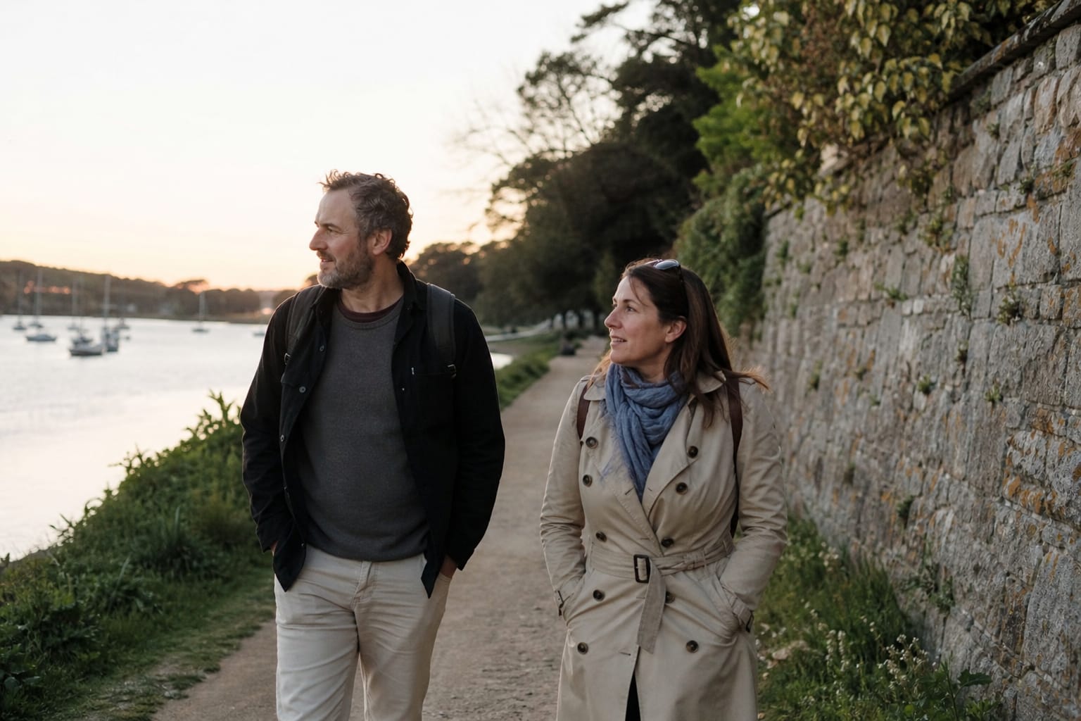 Couple de promeneurs sur un chemin plat au bord de l'eau en fin de journée