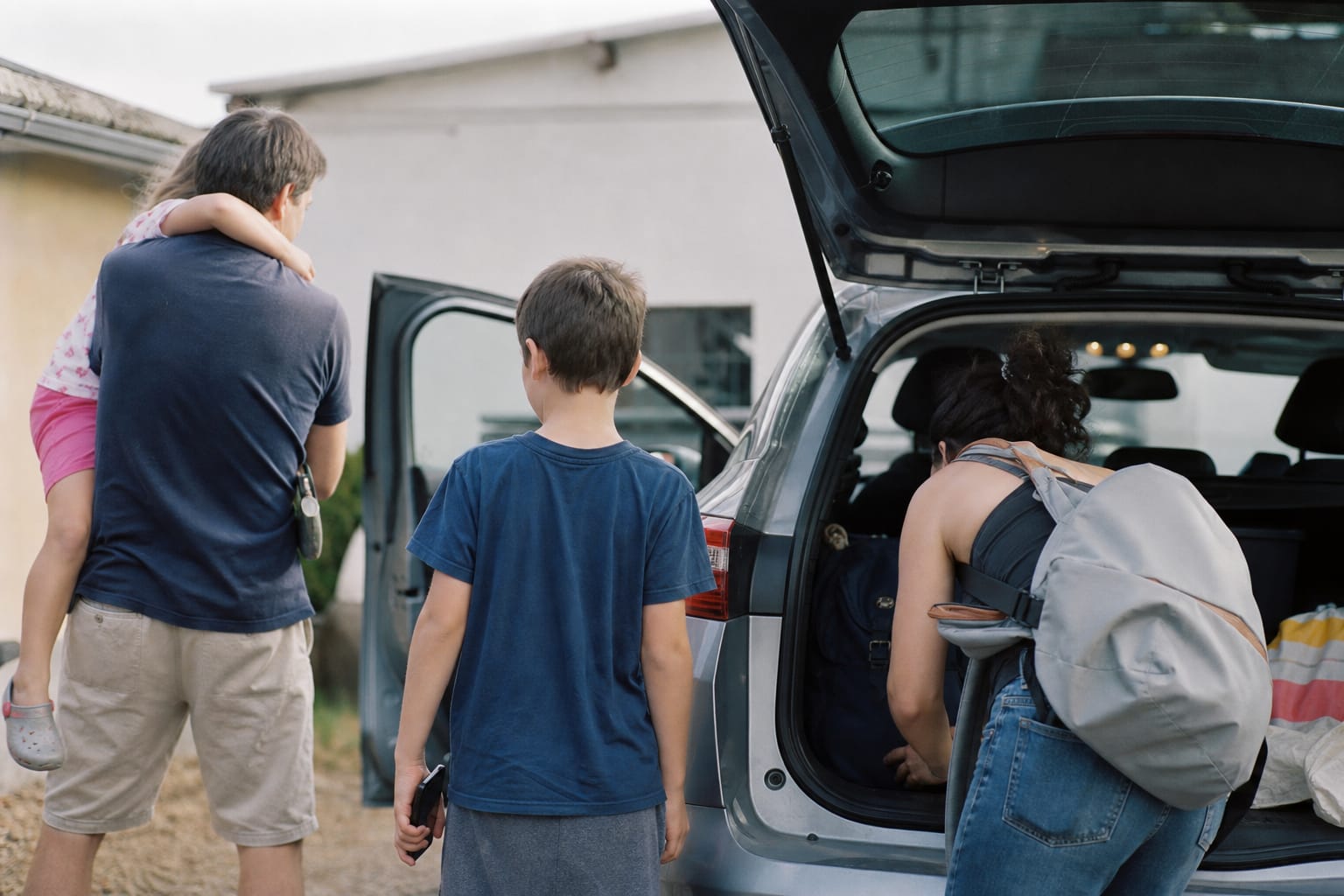 Famille chargeant une voiture pour un départ en vacances